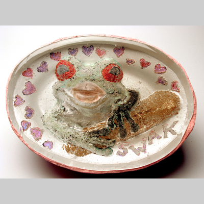- SWAK - A frog inside the glass with human lips extending outside the glass.  Inspired by the tale of the frog prince. Kiln-Cast lead crystal, cast glass & concrete