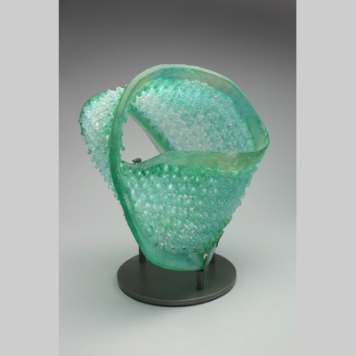 Knitting & Knitted - What Goes Around Comes Around - A mobius strip:  A knitted piece with only one side, and one edge.  The inside becomes the outside, becomes the inside, etc.  Comes with its own custom made stand. Kiln-Cast lead crystal knitted glass