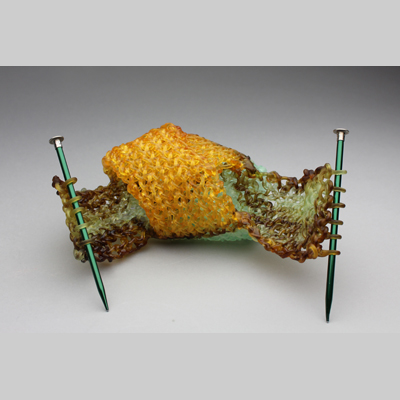 Knitting & Knitted - Confluence - Two colors, pale green and yellow, chemically react to create brownish streaks. kiln cast lead crystal & knitting needles